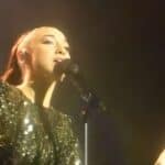 Stunning female singer performing on stage at Viral Music FM with a glittering outfit, captivating the audience with her voice.