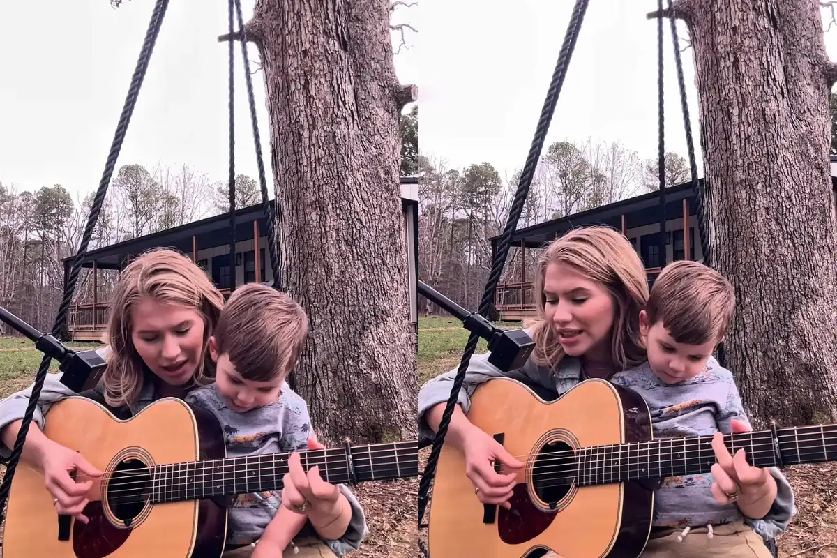 Mother teaching son guitar outdoors in a park.